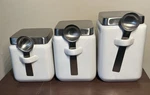 Oggi 3 Piece Ceramic Square Canister Set W/ Stainless Steel Spoon & Lid White. Fixed Price $25.97.